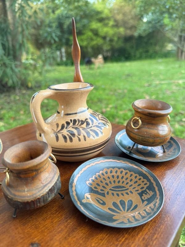 7 adornos varios (cantaro en gade decorado a mano, dos calderos artesanales en madera rustica, platos con diseño de animales en cobre, escultura en madera de un ave y espejo)