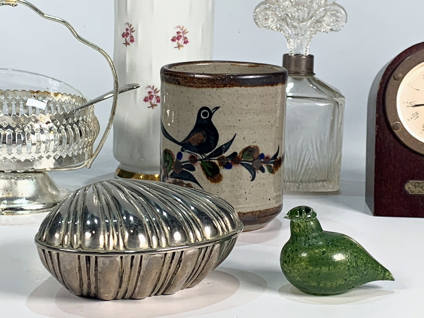 Lote de 8 piezas: Reloj de mesa, coquilla, vaso, florero, dulcera, depósito, perfumero y pájaro decorativo
