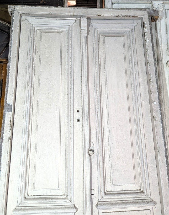 Puerta de dos hojas batientes en cedro con diseño de tablero y manotones de bronce - imagen 9