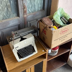 Lote siguiente: Máquina de Escribir Antigua y Estantería de Madera