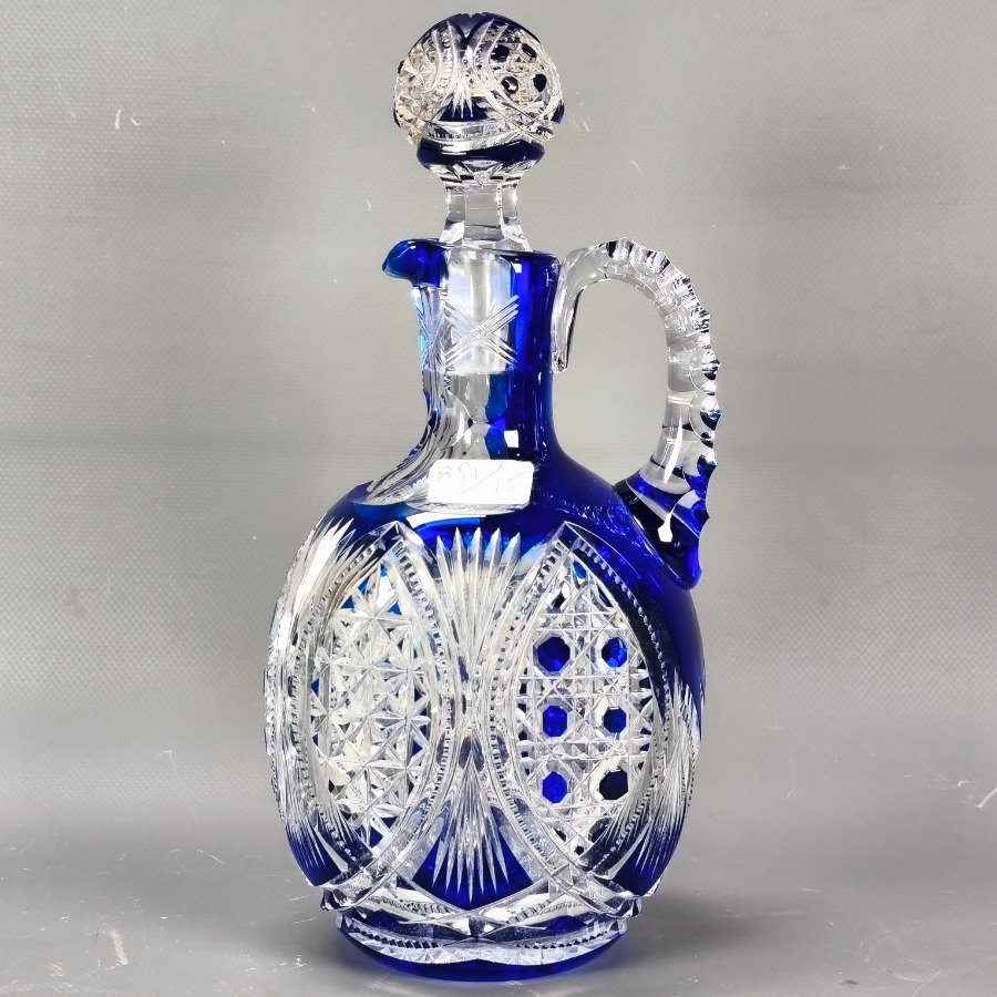 Lote siguiente: Botellón de cristal tallado en tonos hialinos y azul