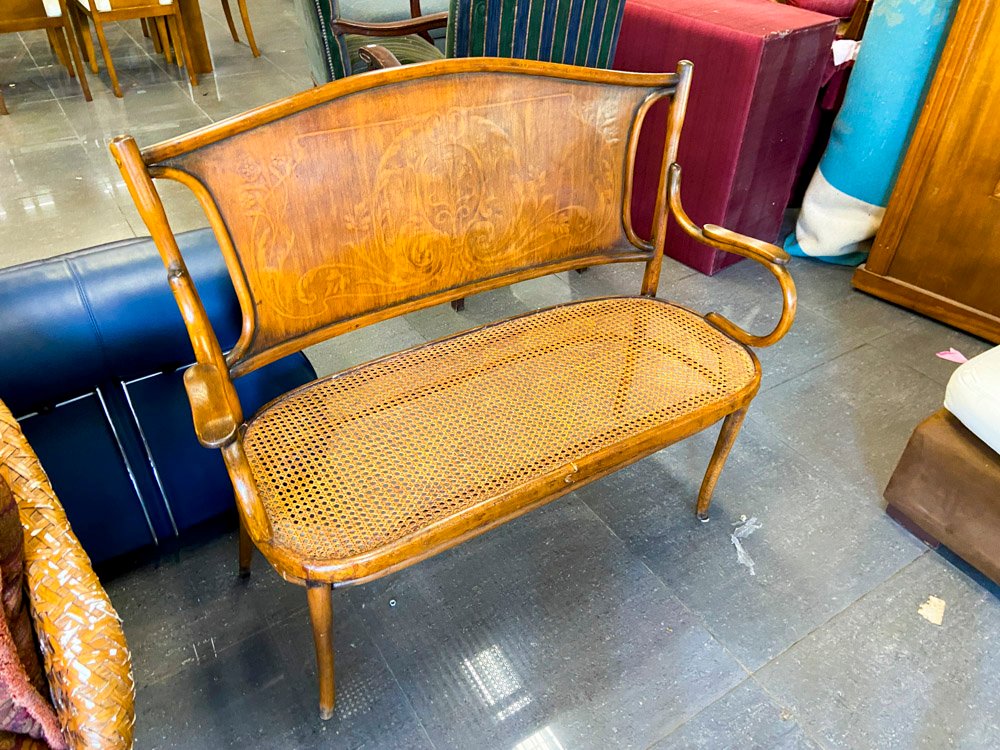 Banco de madera con asiento de mimbre y detalles tallados