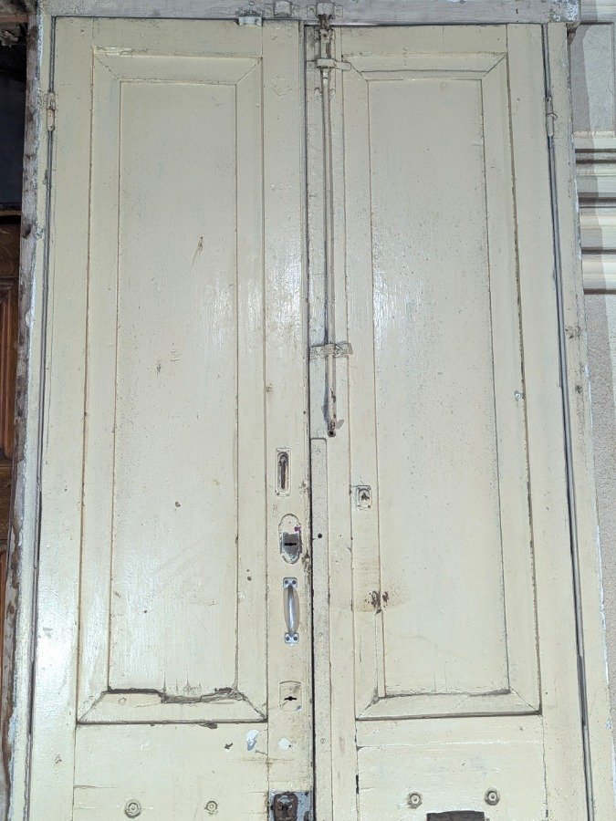 Puerta de dos hojas batientes en cedro con diseño de tablero y manotones de bronce - imagen 12