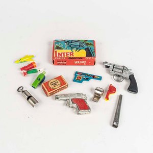Lote siguiente: Lote de juguetes antiguos: Dos revolver uno con fulminantes y 9 silbatos de plástico y metal.