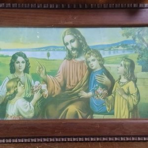 Lote siguiente: La imagen muestra un cuadro antiguo con un marco de madera rectangular que enmarca una lámina litográfica religiosa de estilo clásico