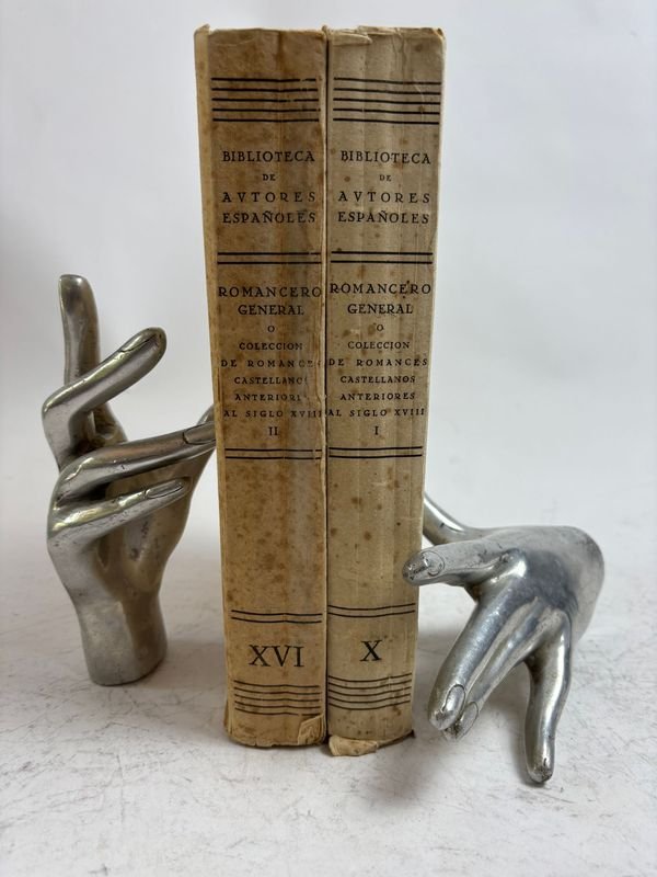 Libros antiguos de autores españoles con esculturas en mano y dedo
