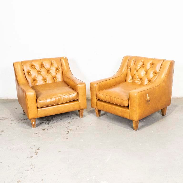 Sillones de cuero marrón con detalles de tapizado y respaldos capitoneados