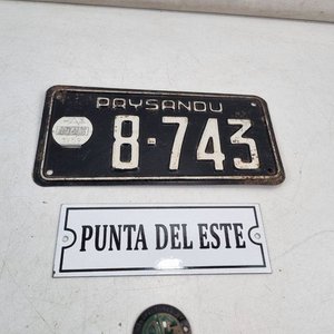 Lote siguiente: L 356 - 4 Piezas - Importante lote de chapas antiguas de colección con patente de Paysandú, cartel de Punta del Este y escudo 'Manufactured by Royal Enfield Motorcycles'