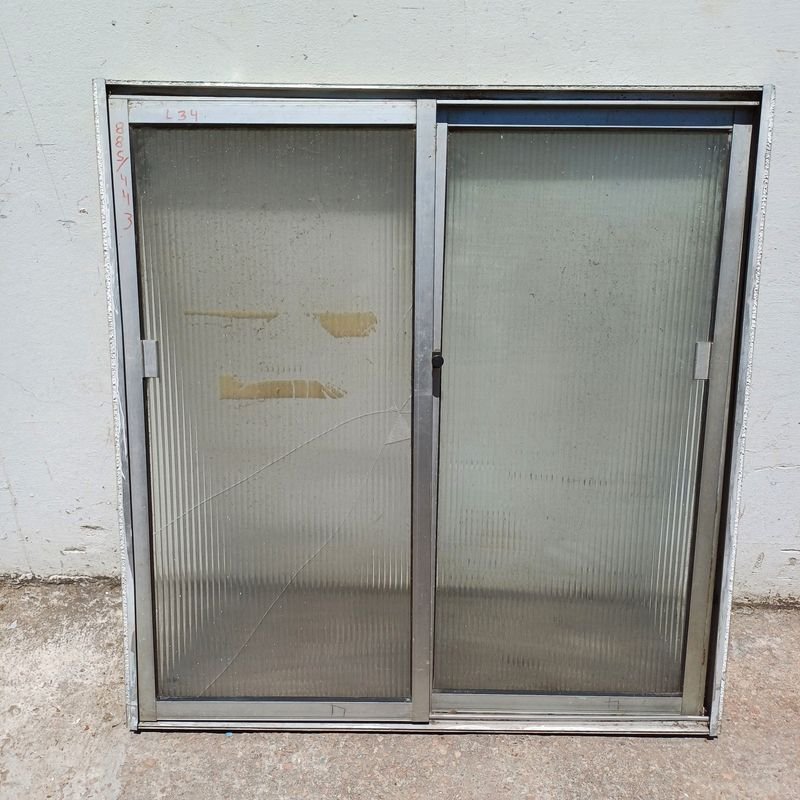 Lote siguiente: Ventana de aluminio con dos hojas corredizas en mal estado